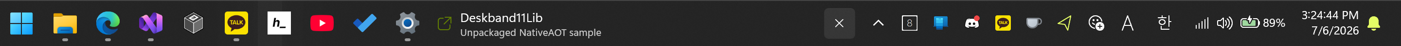 Windows 11 taskbar with the Deskband11Lib WinUI 3 sample between the app buttons and the notification area